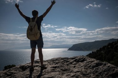 Başarı kavramı. Uzun yürüyüşe çıkan kimse kaldırdı elleriyle bir dağın tepesinde duran ve manzarayı sırt çantası ile