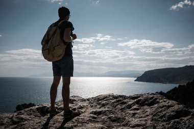 Başarı kavramı. Uzun yürüyüşe çıkan kimse kaldırdı elleriyle bir dağın tepesinde duran ve manzarayı sırt çantası ile