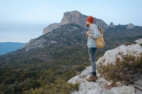Sırt çantalı bir adam dağda yürüyüş yapıyor.