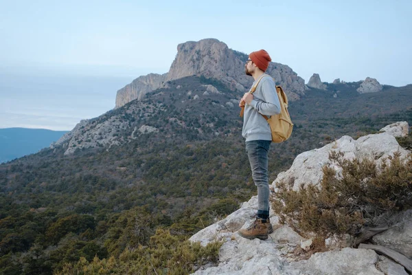Sırt çantalı bir adam dağda yürüyüş yapıyor.