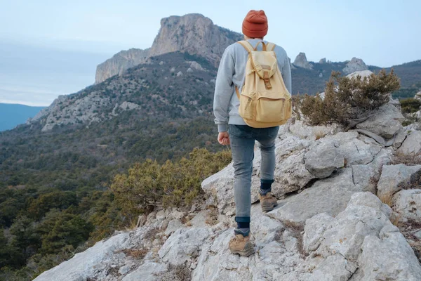 Sırt çantalı bir adam dağda yürüyüş yapıyor.