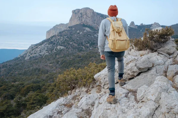 Sırt çantalı bir adam dağda yürüyüş yapıyor.