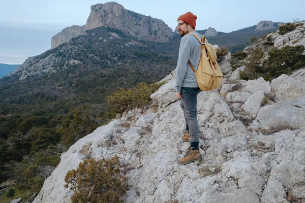 Sırt çantalı bir adam dağda yürüyüş yapıyor.