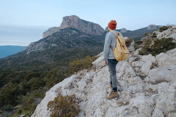 Sırt çantalı bir adam dağda yürüyüş yapıyor.