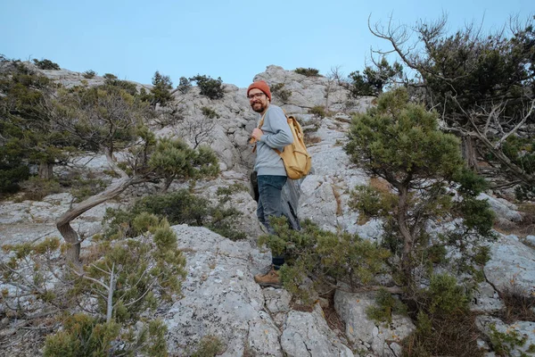 Sırt çantalı bir adam dağda yürüyüş yapıyor.