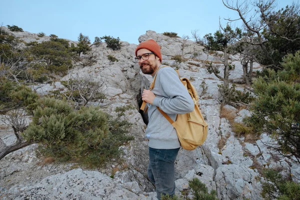 Sırt çantalı bir adam dağda yürüyüş yapıyor.