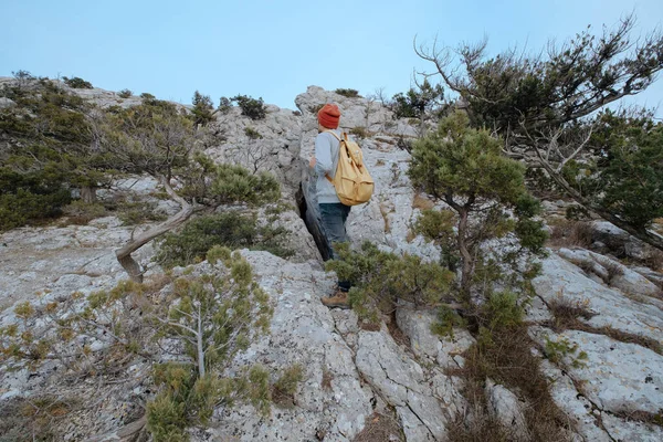 Sırt çantalı bir adam dağda yürüyüş yapıyor.