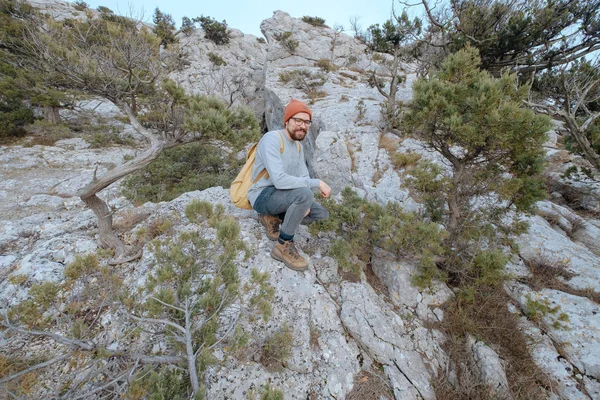 Sırt çantalı bir adam dağda yürüyüş yapıyor.