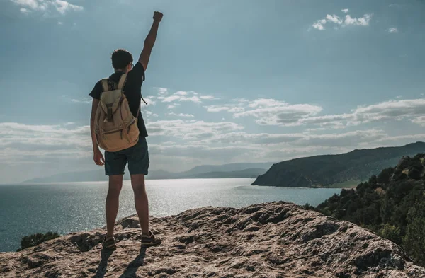 Concepto de éxito. Caminante con mochila de pie en la cima de una montaña con las manos levantadas y disfrutando de la vista — Foto de Stock