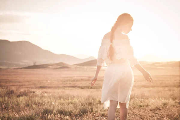 Ragazza dai capelli rossi in un campo di grano in un vestito bianco sorride un bel sorriso — Foto Stock