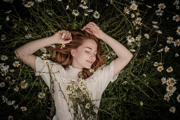 Belle femme appréciant le champ de marguerite, belle femelle couchée dans — Photo