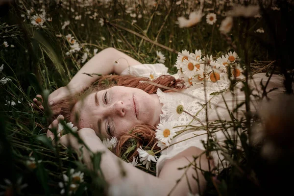 Belle femme appréciant le champ de marguerite, belle femelle couchée dans — Photo