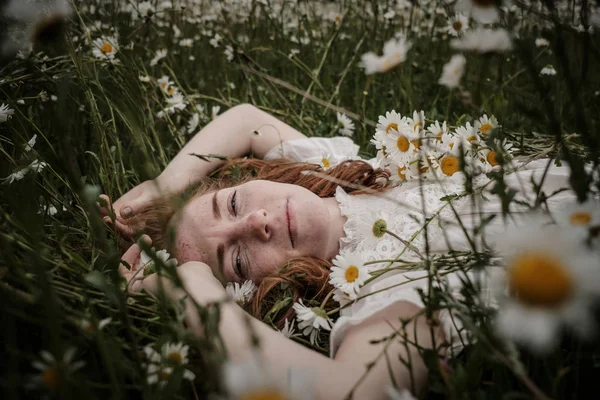 Belle femme appréciant le champ de marguerite, belle femelle couchée dans — Photo