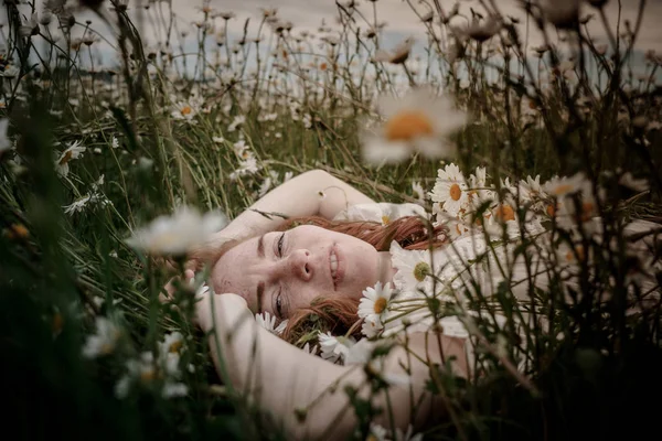 Beautiful woman enjoying daisy field, nice female lying down in — Stock Photo, Image