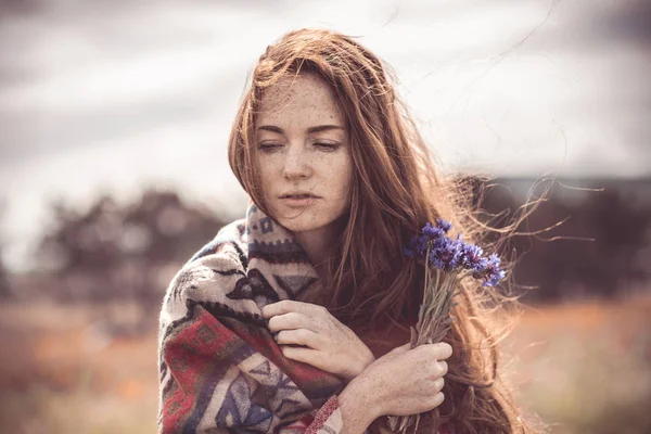 A beautiful girl enjoys the smell of a bouquet of cornflowers. W — Stock Photo, Image