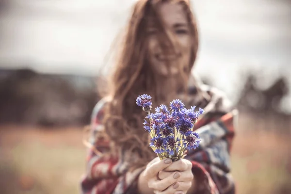 Ein schönes Mädchen genießt den Duft eines Straußes Kornblumen. w — Stockfoto