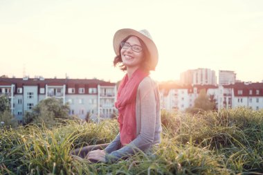 Güzel genç kadının bir tepenin üstüne günbatımı.