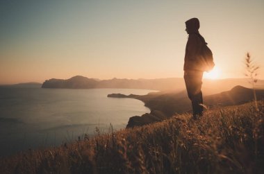 Sırt çantası olan genç duran adam.