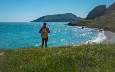 Sırt çantası olan genç duran adam.