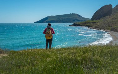 Sırt çantası olan genç duran adam.