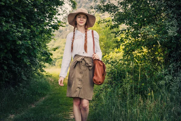 Viajero mujer con mochila y sombrero caminando — Foto de Stock
