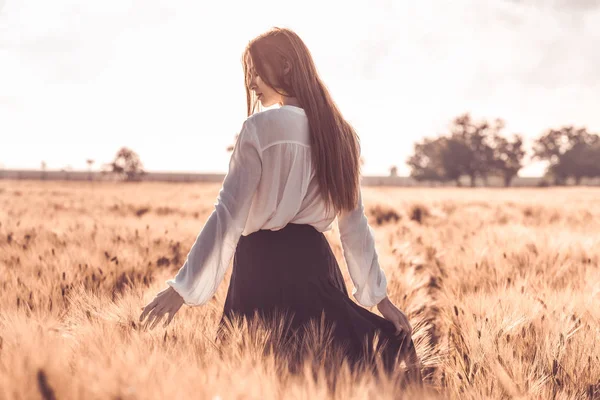Rusovlasá dívka v pšeničné pole při západu slunce. — Stock fotografie
