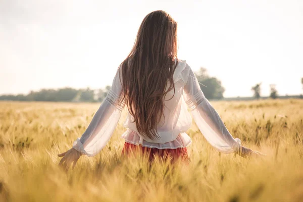 Ragazza dai capelli rossi in un campo di grano al tramonto . — Foto Stock