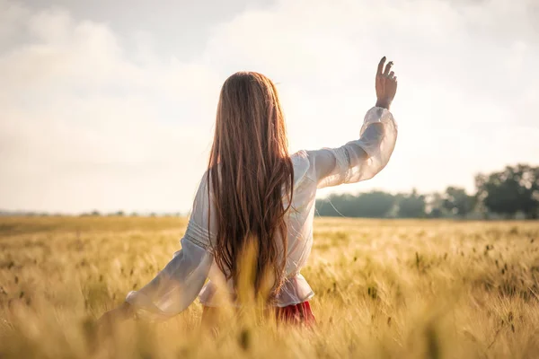 Ragazza dai capelli rossi in un campo di grano al tramonto . — Foto Stock