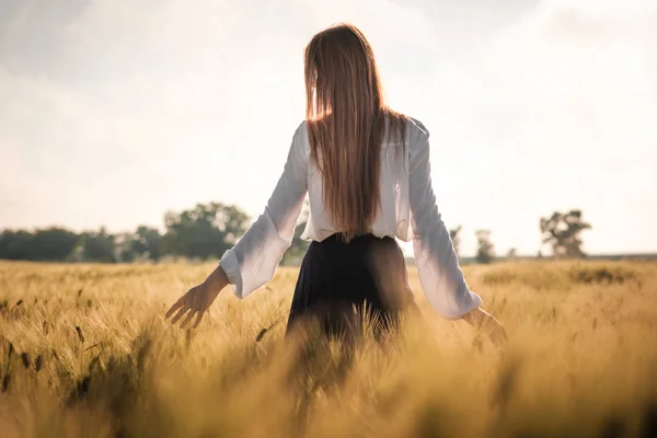 Ragazza dai capelli rossi in un campo di grano al tramonto . — Foto Stock