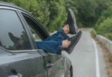 Araba yolun ormandaki yukarıda Windows'da kadın bacakları dışarı