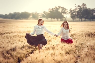 İki genç kadın günbatımı için sabırsızlanıyoruz. En iyi dostlar