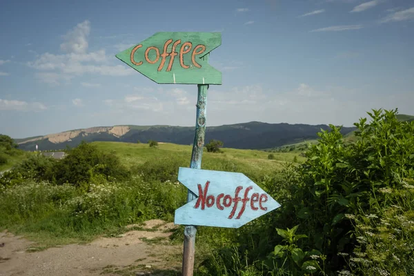 Funny signpost on a mountain road near a small cafe