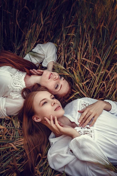 Dos mujeres jóvenes están deseando el atardecer. Mejores amigos — Foto de Stock