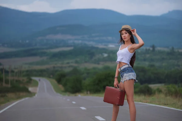 Ženy je osvobozena auto na silnici. Thumbing svézt. Dovolená v přírodě.. — Stock fotografie