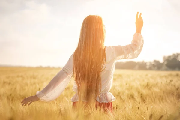 Ragazza dai capelli rossi in un campo di grano al tramonto . — Foto Stock