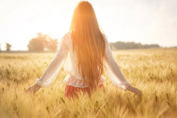 Ragazza dai capelli rossi in un campo di grano al tramonto . — Foto Stock