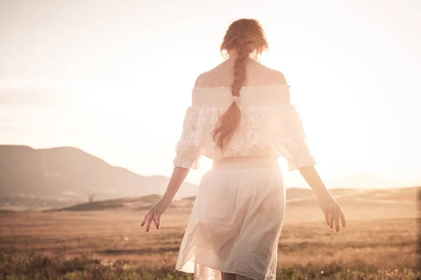 Ragazza dai capelli rossi in un campo di grano in un abito bianco sorride a lo — Foto Stock