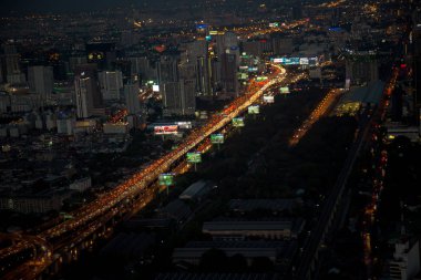 Bangkok manzarası ve gökdelen iş Bangkok şehir merkezinde Sathorn Road üzerinde ışık yollar ile havadan görünümü.