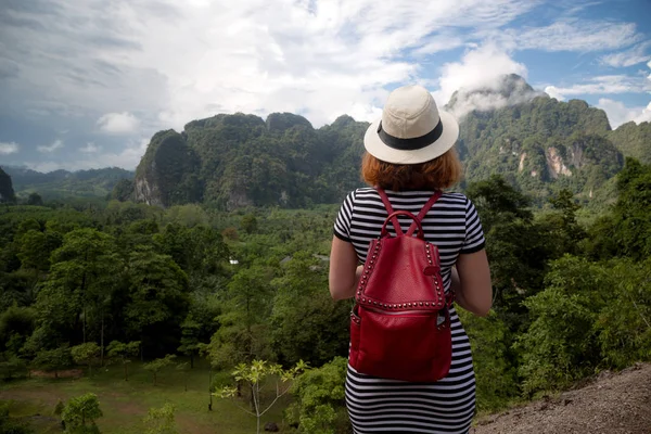 红头发的女人旅行者背包和帽子, 看着阿玛兹 — 图库照片