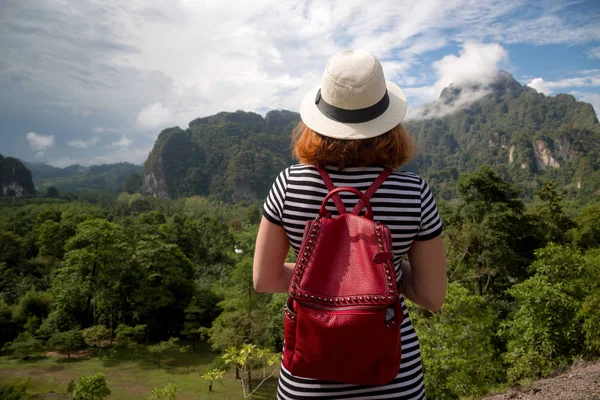 红头发的女人旅行者背包和帽子, 看着阿玛兹 — 图库照片