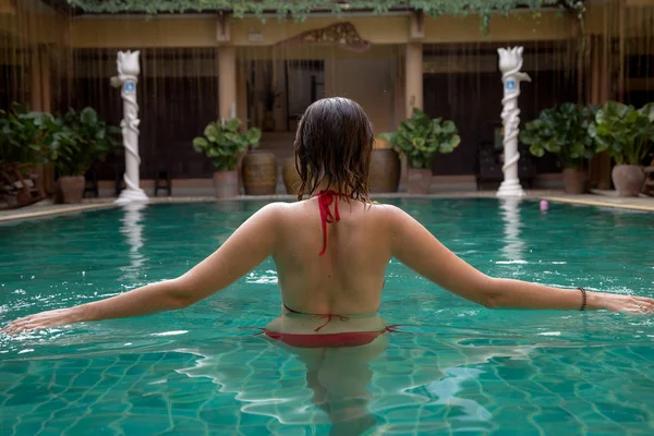 Girl at travel spa resort pool. Summer luxury vacation.