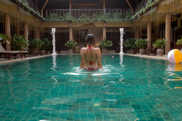 Girl at travel spa resort pool. Summer luxury vacation.