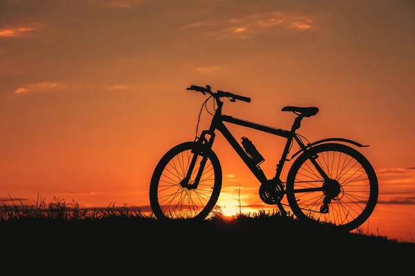 Silhouet van een mannelijke mountainbiker bij zonsondergang in de bergen — Stockfoto