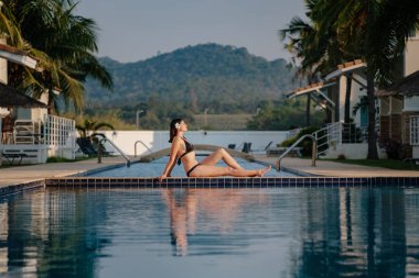 Güzel yüzme havuzunun yakınında rahatlatıcı kadın.