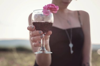 Güllerin yanında poz veren kıvırcık saçlı güzel bir kadın.