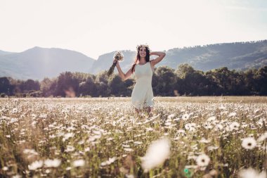 Papatya alanı üzerinde gülümsüyor güzel genç kız.