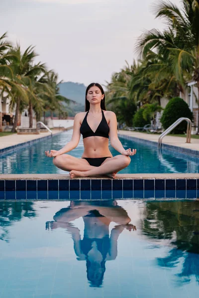 Esmer kız havuzda güneşleniyor ve dinleniyor.