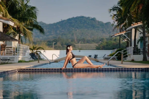 Güzel yüzme havuzunun yakınında rahatlatıcı kadın.