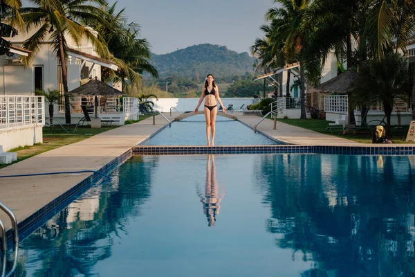 Havuz kenarındaki mayo ince genç bir kadının tam uzunlukta çekim.
