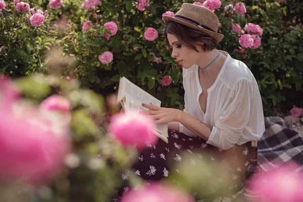 güzel kız kitabı ile şapka giymiş çim üzerinde oturan gül gaden